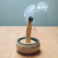 Kadeča Palo Santo palčka zapičena v pesek v posodici – sveti les za čiščenje prostora, umirjanje in meditativni ritual.