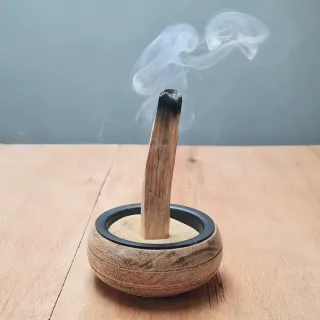 Kadilo palo santo ali sveti les, ena kadeča se palčka zapičena v v pesek