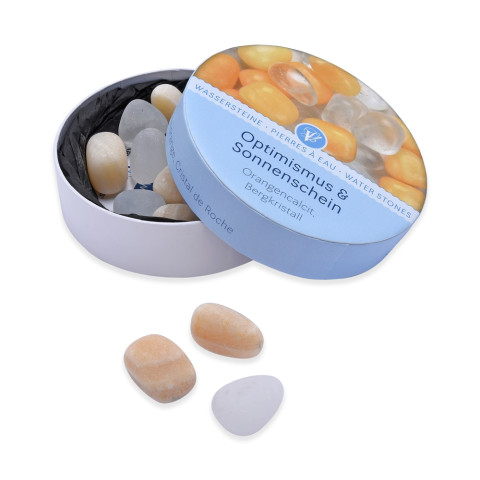 Cardboard box containing orange calcite and rock crystal gemstones for revitalizing drinking water.
