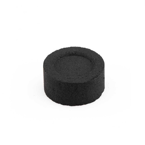 Round black charcoal tablet for burning incense on a white background